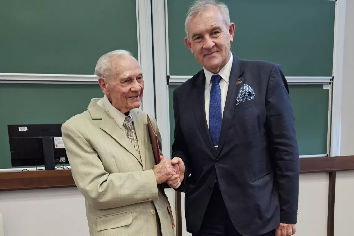 Dwaj elegancko ubrani mężczyżni ściskają sobie dłoń w geście gratulacji i podziekowania