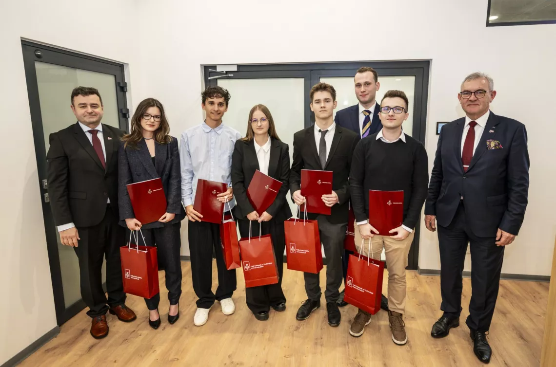 Grupa stypendystów z rektorem i prorektorem ds. kształcenia