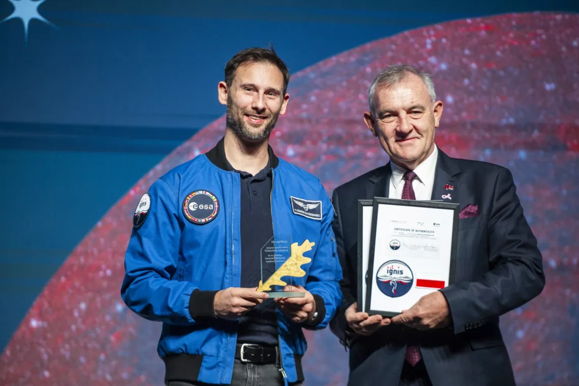 Kosmonauta misji IGNIS z tytułem „Wybitnego Absolwenta Politechniki Łódzkiej” i rektor z certyfikatem z logo IGNIS i polską flagą, która była w kosmosie