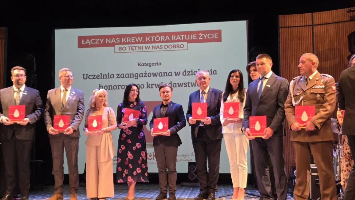 Wyróżnione osoby stoją na scenie w tle ekran z napisem Łączy nas krew, która ratuje życie