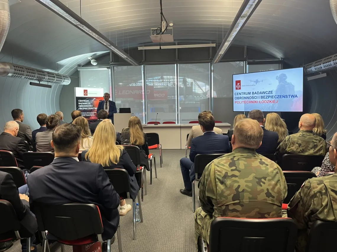 W czasie seminarium, słuchacze siedzą w sali, na ekarnie wyświetla się prezentacja