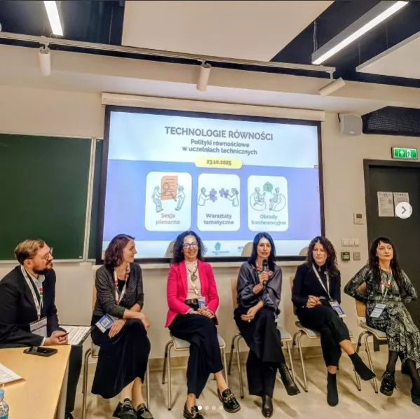 Sześć osób uczestniczących w panelu, z tyłu ekran, na którym wyświetlana jest prezentacja