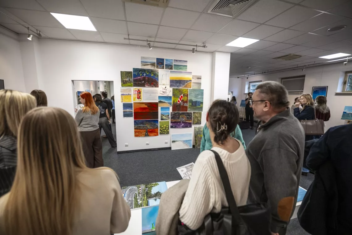 Osoby oglądają prace na wernisażu wystawy