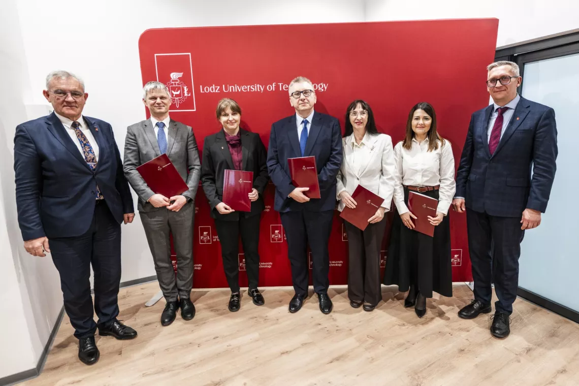 Laureatki i laureaci stypendium profesorskiego trzymają teczki w rękach, obok stoją dwaj mężczyni w garniturach 