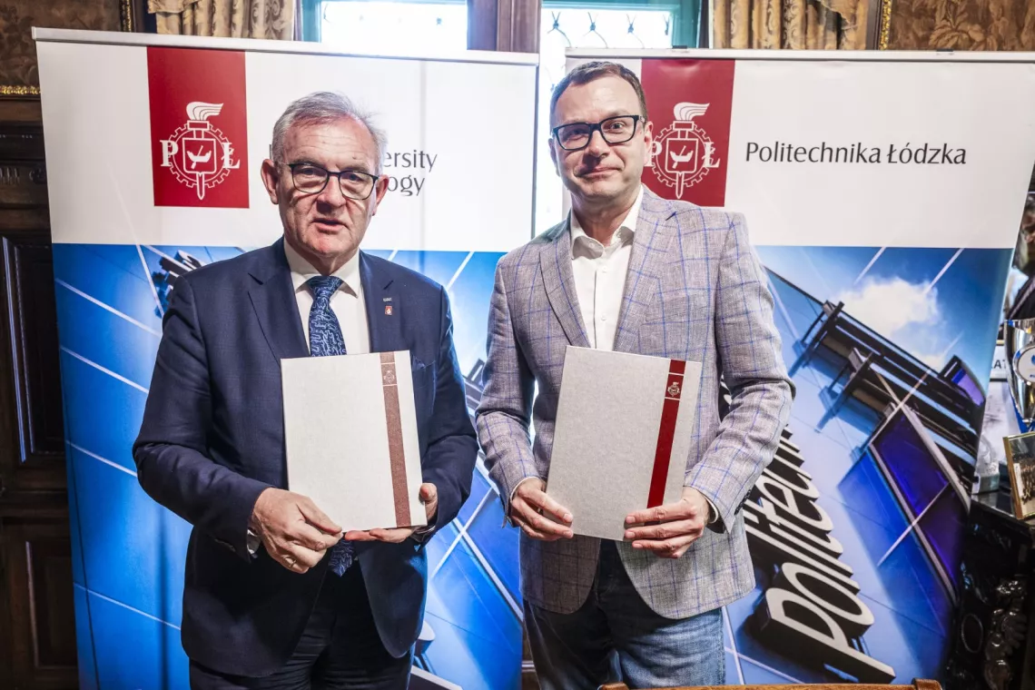 Dwóch elegancko ubranych mężczyzn w okularach trzyma w rękach srebrne okładki do dokumntów