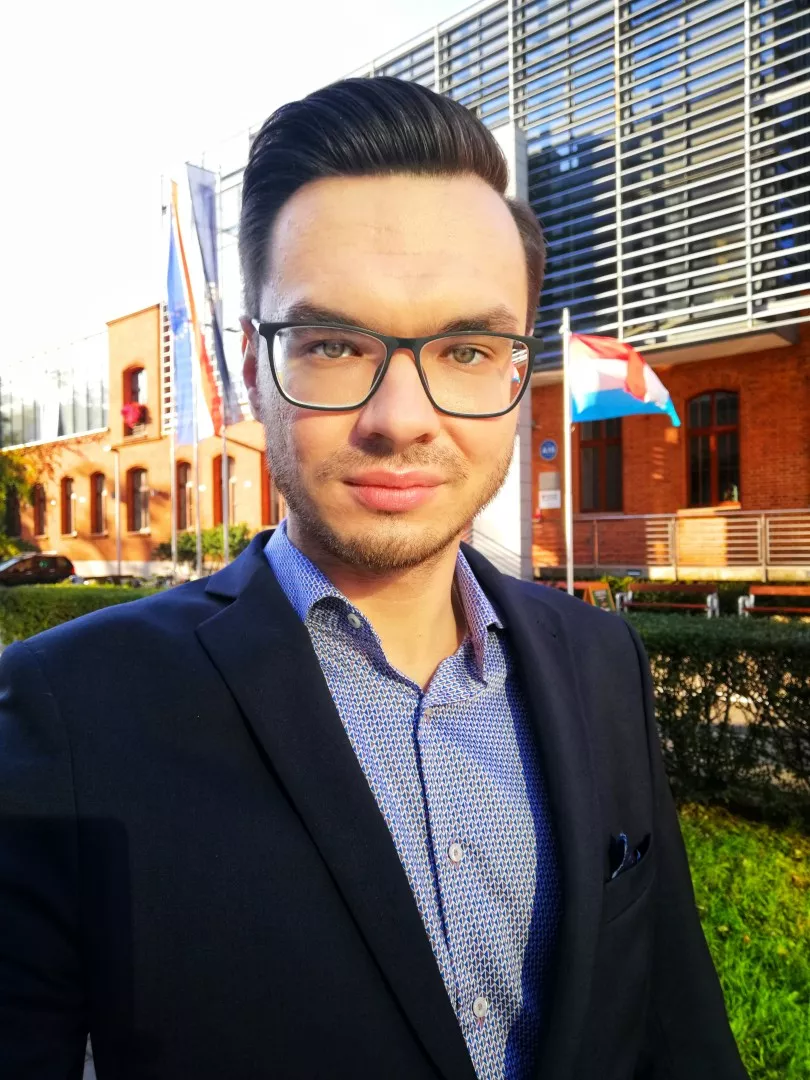 Dr Kamil Lubiński na tle budynku IFE