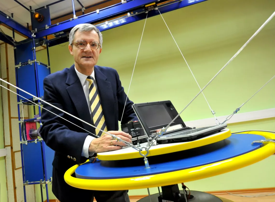 Prof. Andrzej Bartoszewicz przy platformie wiszącego robota o sześciu stopniach swobody 
