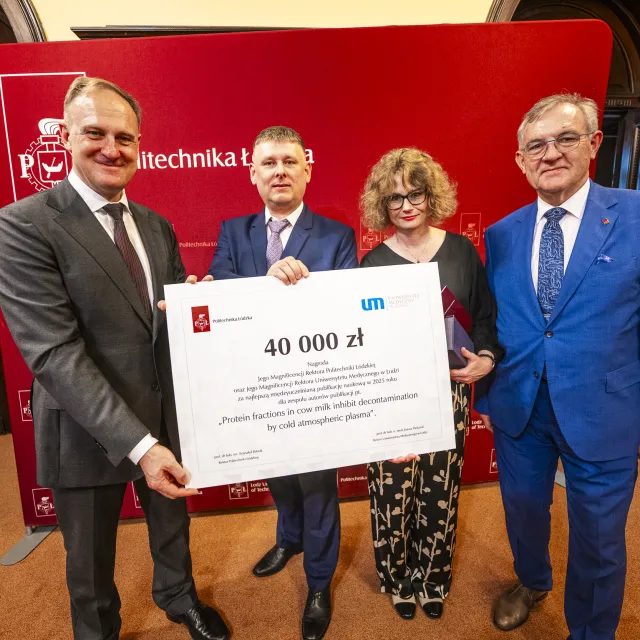 Kobieta i trzech mężczyzn trzyma wspólnie czek w symbolicznej postaci na kwotę 40 tysięcy złotych