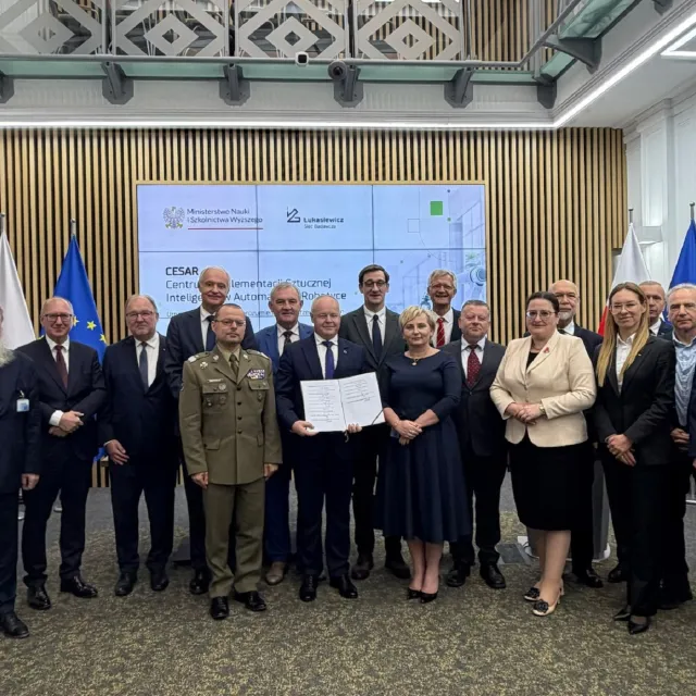 Sygnatariusze porozumienia - zbiorowe zdjęcie. W tle ekarn z napise CESAR, po bokach stoją flagi